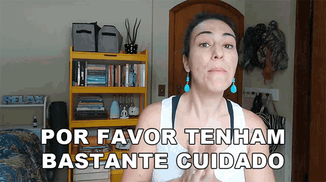 a woman stands in front of a yellow bookshelf that says por favor tenham bastante cuidado