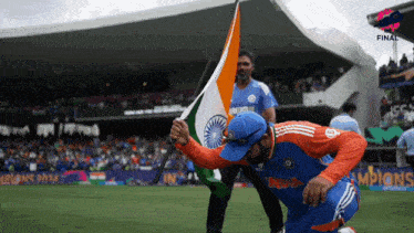 a man kneeling down holding a flag that says ' india ' on it