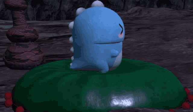 a blue cartoon character is laying on a green object
