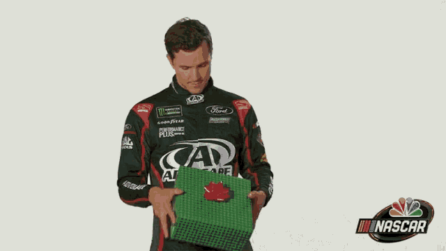 a man wearing a nascar shirt is holding a green item