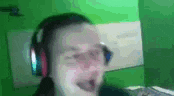 a man is wearing headphones and making a funny face .