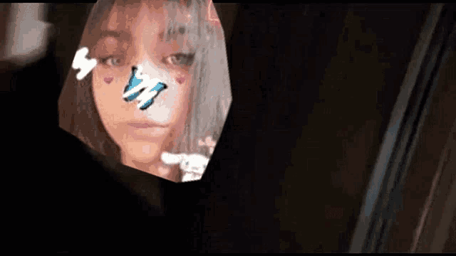 a girl is looking at herself in a mirror with a butterfly on her face .