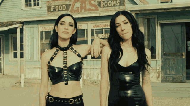 two women standing in front of a building that says food gas rooms