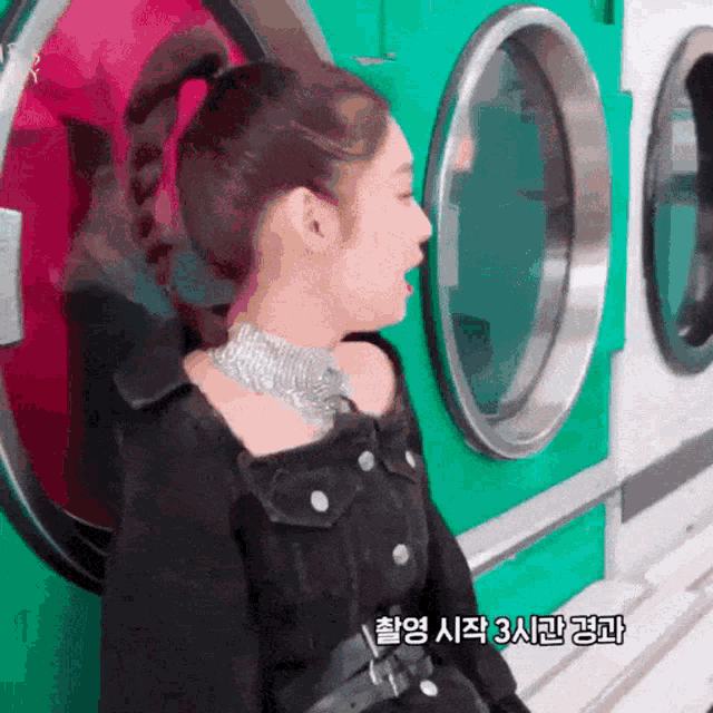 a woman in a ponytail is standing in front of a laundromat machine
