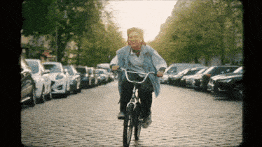 a woman is riding a bike down a brick street