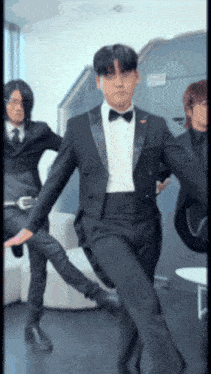 a man in a tuxedo with a bow tie is dancing
