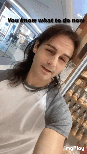 a man with long hair is taking a selfie with the caption " you know what to do now " above him