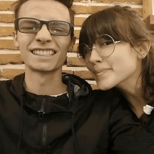 a man and a woman wearing glasses are posing for a photo