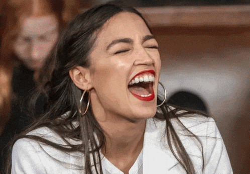 a woman with red lipstick and hoop earrings is laughing with her eyes closed
