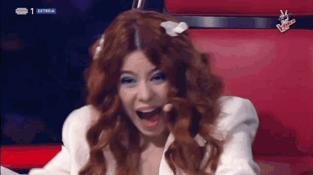 a woman with red hair is sitting in a red chair with a sign that says australia on it
