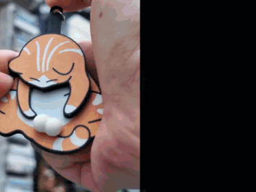 a close up of a person holding a cat shaped ornament