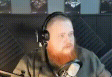 a man with a beard is wearing headphones and a microphone .