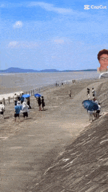 a group of people are walking down a path next to a body of water with a caption that reads capcut