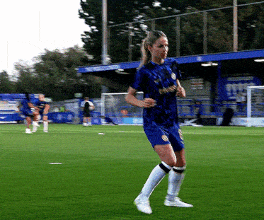 a female soccer player wearing a blue shirt that says ' chelsea ' on it