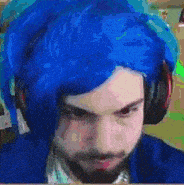 a man with blue hair is wearing headphones and a blue jacket .
