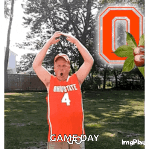 a man in a red ohio state jersey stands in front of a large ohio state logo
