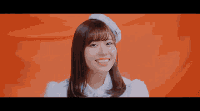 a young woman wearing a white hat and a white shirt smiles for the camera