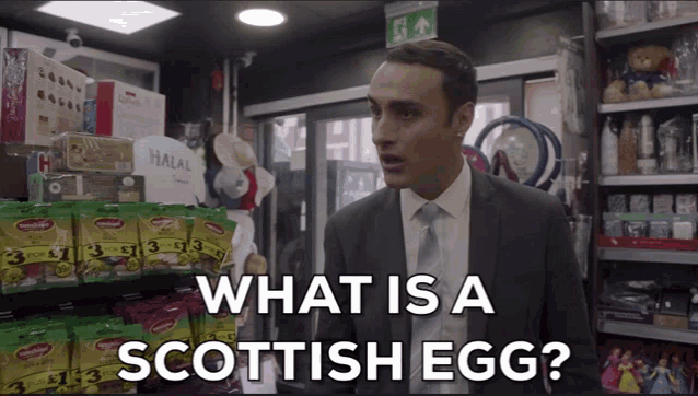 a man in a suit and tie asks what is a scottish egg in a store