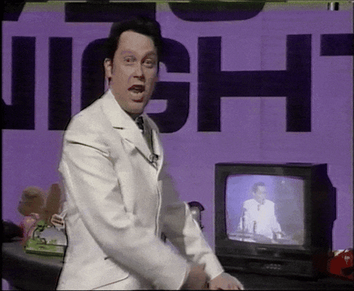 a man in a white suit is standing in front of a sign that says " night "
