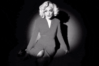a woman in a red dress is kneeling down in front of a blue light