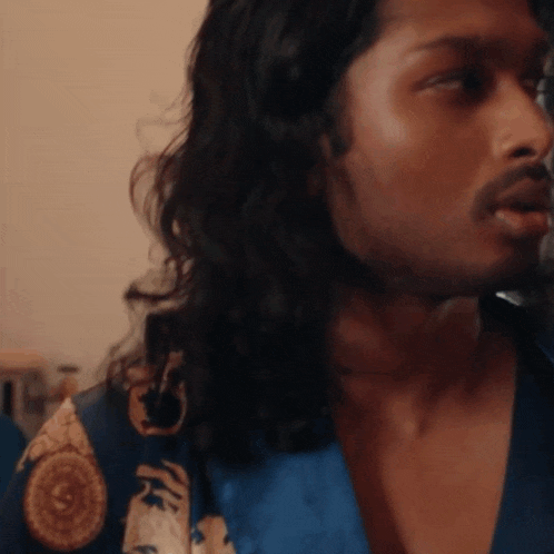 a man with long hair and a beard wearing a blue robe