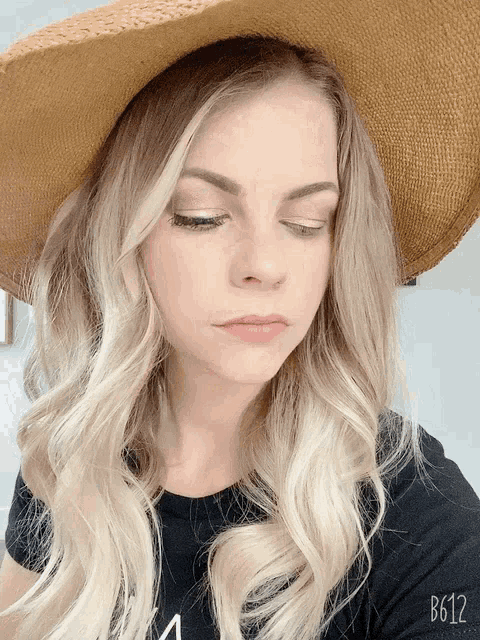 a woman wearing a hat and a black shirt with the number b612 on the bottom