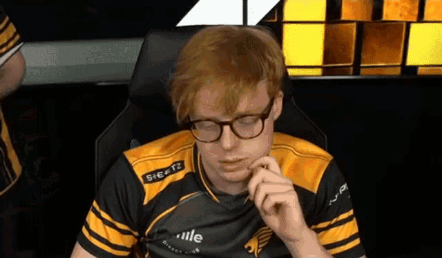 a man wearing glasses is sitting in a chair with his mouth open