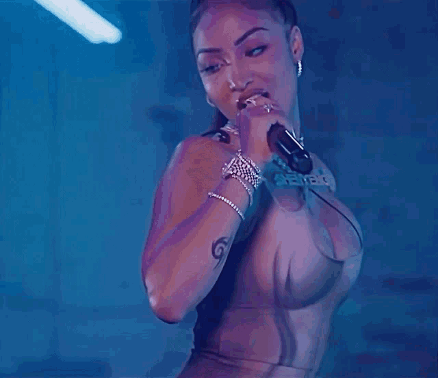 a woman in a very revealing top is smiling and wearing hoop earrings