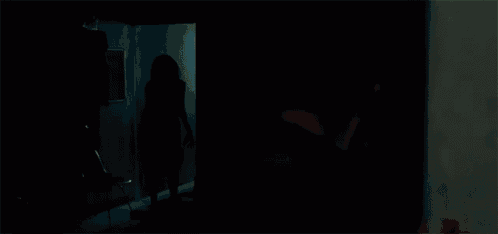 a person is standing in a room with clothes hanging on the racks