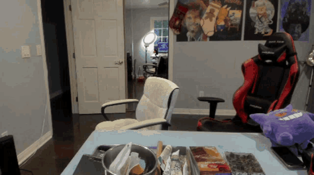 a room with a red and black chair and a purple stuffed animal with the word pokemon on it