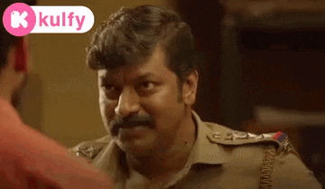 a police officer with a mustache is talking to another man .