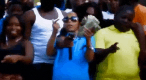 a man is holding a gun in front of a crowd of people while dancing .