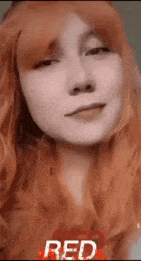 a close up of a woman 's face with red hair