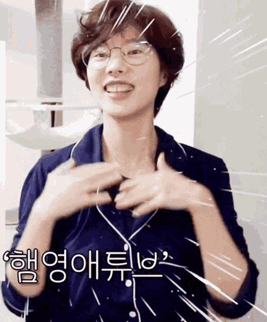 a woman wearing glasses and a blue shirt is making a funny face with chinese writing behind her