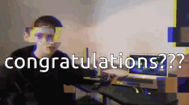 a man is sitting at a desk with a laptop and the words congratulations