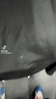 a person wearing a black shirt with tik tok written on it