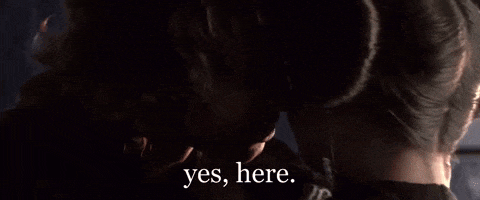 a close up of a person holding another person 's head with the words `` yes , here '' written on the bottom .