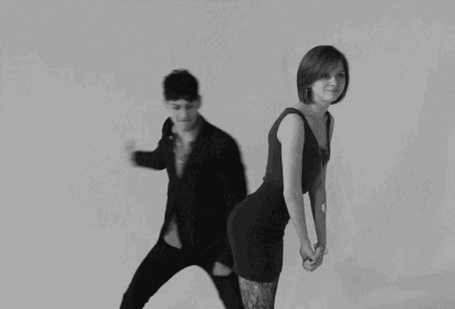a man in a suit and a woman in a dress are dancing together