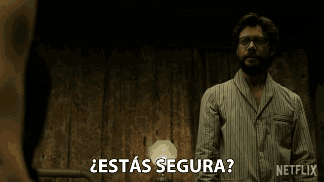 a man in a striped shirt is standing in front of a lamp and says " estas segura "