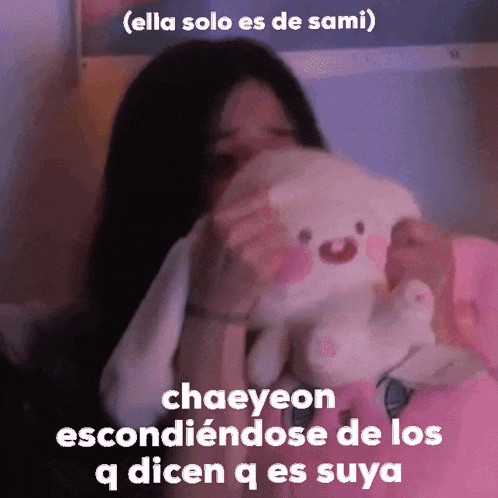 a girl is holding a stuffed animal with the words chaeyeon escondiendose de los qdicen q es suya