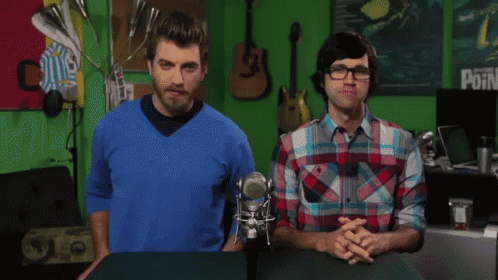 two men are standing in front of a green screen with a sign that says point