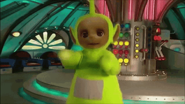a teletubbies character is standing in front of a machine