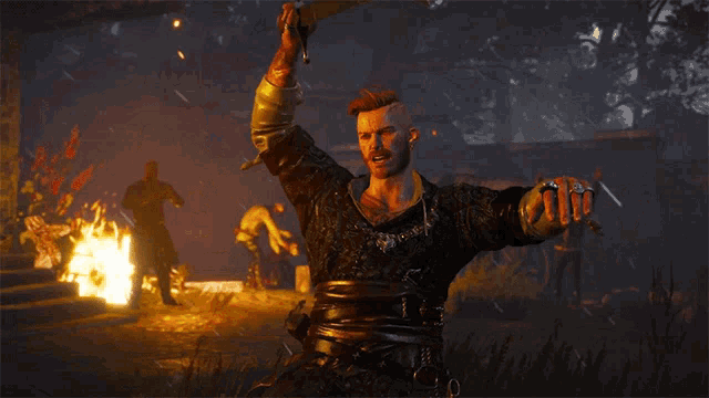 a man is holding a yellow sword in front of a fire