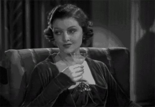 a woman is sitting in a chair holding a glass of wine