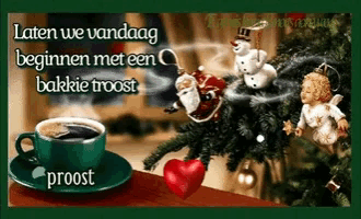 a green cup of coffee sits on a saucer next to a christmas tree and a heart