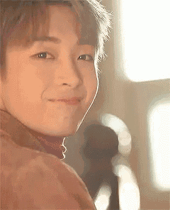 a close up of a young man 's face with a smile on his face .