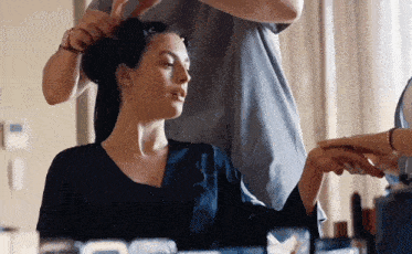 a woman is getting her hair done by a hairdresser