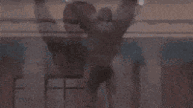 a woman is hanging from a rope in the air while a man stands behind her .