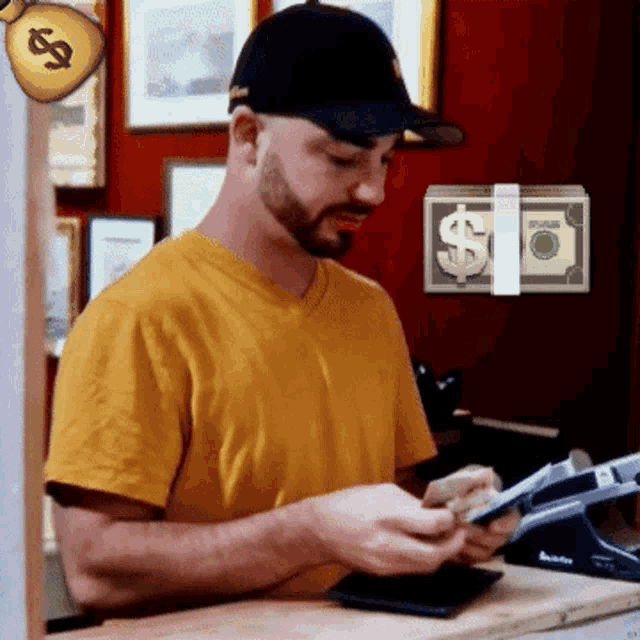a man in a yellow shirt looks at a stack of dollar bills