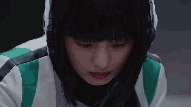 a close up of a woman wearing headphones and looking down